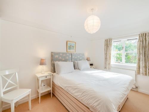 a bedroom with a bed and a chair and a window at Snaylam House Cottage in Rye