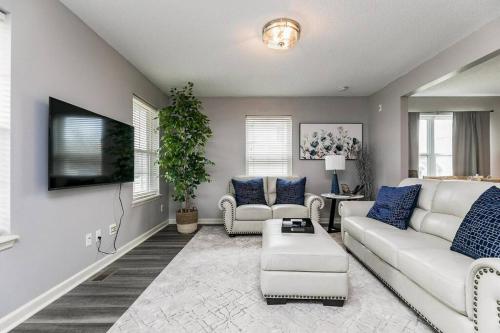 a living room with a white couch and blue pillows at Cozy Modern Newbo Area Home in Cedar Rapids