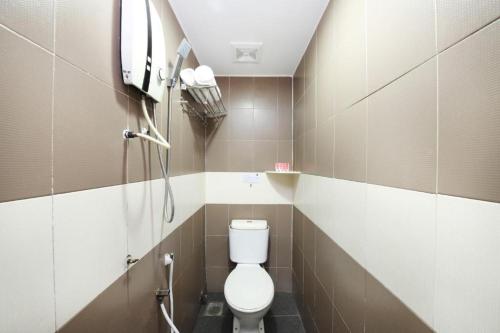 a small bathroom with a toilet and a tv at Hotel Inap in Batu Caves