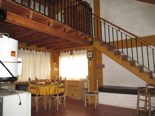 a kitchen and dining room with a staircase and a table at Cabañas Los Arreboles in Potrerillos