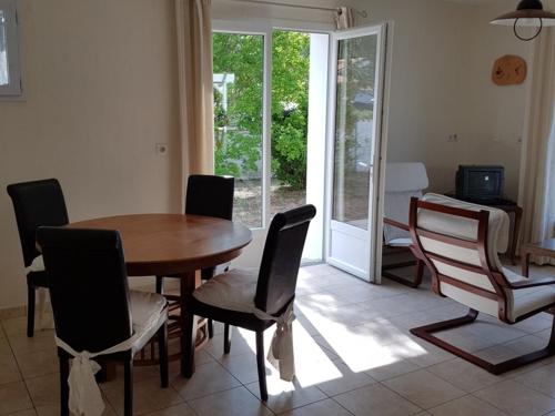 une salle à manger avec une table et des chaises en bois dans l'établissement Charmante maison boisée près de la plage - 4 pers, animaux sur demande, jardin clos, calme assuré - FR-1-476-122, à La Faute-sur-Mer