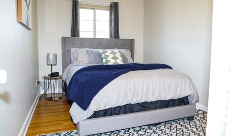 1 dormitorio con 1 cama con manta azul y blanca en Franklin Park 3BR Condo near Airport, Downtown, OSU, en Columbus