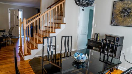 a living room with a glass table and a staircase at Franklin Park 3BR Condo near Airport, Downtown, OSU in Columbus