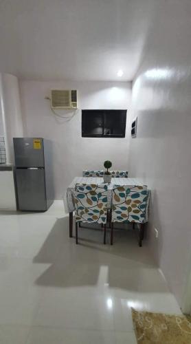 Dieses weiße Zimmer verfügt über einen Tisch und einen Kühlschrank. in der Unterkunft Elvie Medida House for Rent in Boljoon