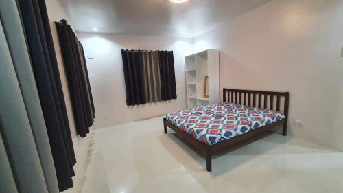 ein Schlafzimmer mit einem Bett in einem Zimmer in der Unterkunft Elvie Medida House for Rent in Boljoon
