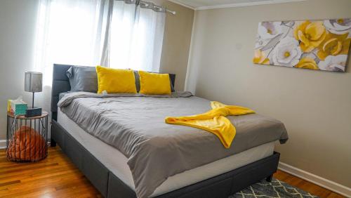 a bedroom with a bed with yellow pillows and a painting at Cozy 3BR Condo near OSU Perfect for Students, Workers & Staycations in Columbus