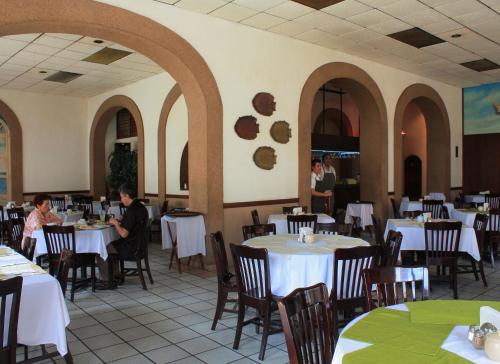 a restaurant with tables and chairs and people sitting at them at Hotel Reforma Tuxpan in Tuxpan de Rodríguez Cano