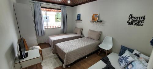 mały pokój z 2 łóżkami i oknem w obiekcie Hospedagem Doce Lar - Casa Bougainville w mieście Teresópolis