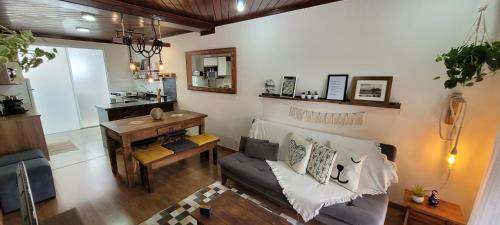 a living room with a couch and a table at Hospedagem Doce Lar - Casa Bougainville in Teresópolis