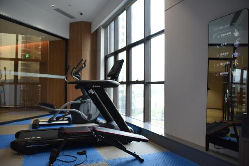 a gym with a exercise bike in a room with windows at Holiday Inn Express Nanning Jiangnan by IHG in Nanning