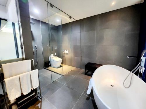 a bathroom with a tub and a toilet and a shower at JS Boutique Hotel in Hwaseong