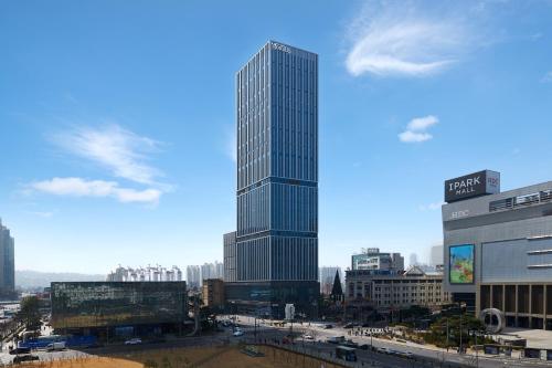 ein großer Wolkenkratzer mitten in einer Stadt in der Unterkunft Nine Tree Premier ROKAUS Hotel Seoul Yongsan in Seoul