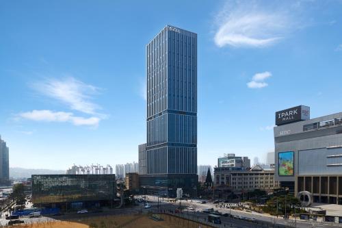 a tall skyscraper in the middle of a city at Nine Tree Premier ROKAUS Hotel Seoul Yongsan in Seoul