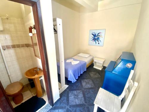 a small bathroom with a bed and a shower at Pousada e Hostel Barra da Tijuca in Rio de Janeiro