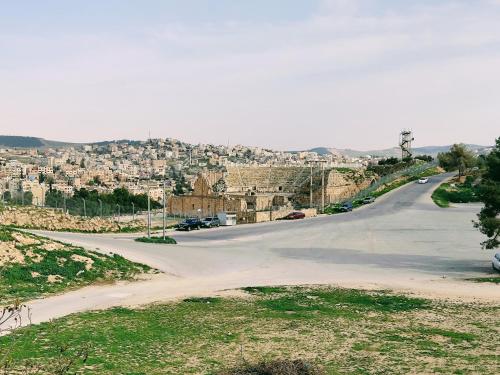 an empty road with a city in the distance at Panorama Jerash HOTEL (2) in Jerash