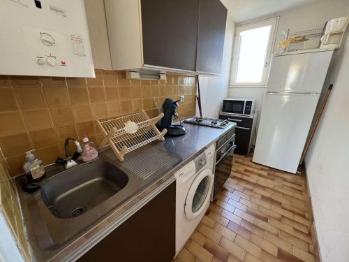 une petite cuisine avec un évier et un réfrigérateur dans l'établissement T2 cabine 6 pers, lave-linge, parking, 100m plage, animaux OK - FR-1-702-53, au Cap d'Agde