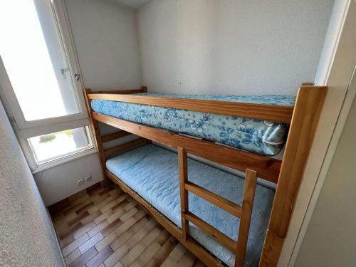 Cette petite chambre dispose de 2 lits superposés et d'une fenêtre. dans l'établissement T2 cabine 6 pers, lave-linge, parking, 100m plage, animaux OK - FR-1-702-53, au Cap d'Agde