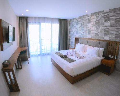 a hotel room with a bed and a large window at Flamingo Bajo Waecicu in Labuan Bajo