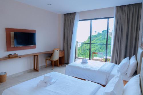 um quarto de hotel com duas camas e uma grande janela em Flamingo Bajo Waecicu em Labuan Bajo