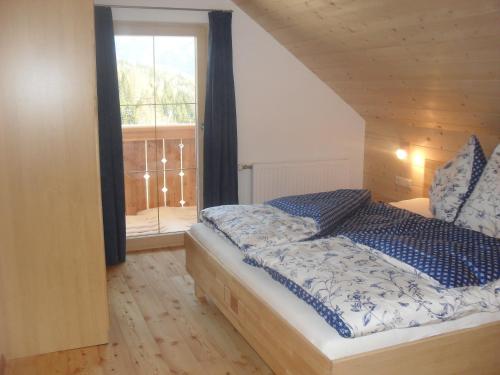 a bedroom with a bed and a large window at Bio-Bergbauernhof Möslhof in Aigen im Ennstal
