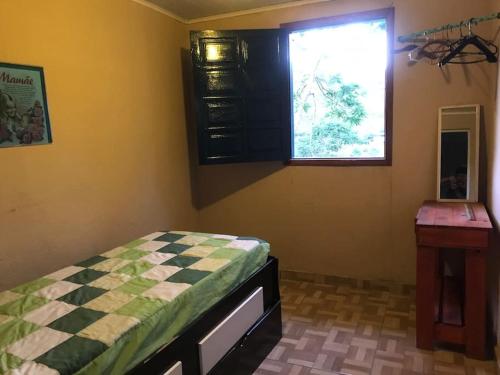a bedroom with a bed and a window at Refúgio, Aconchego, Aonde nasce o sol e Cachoeira! in Mercês