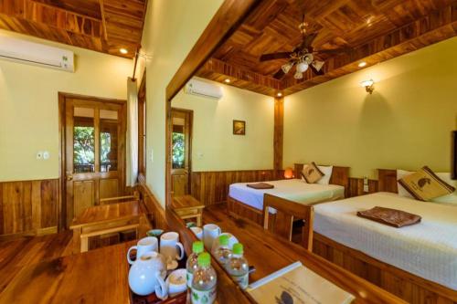 a room with two beds and a table in a room at Mango Beach Resort in Phú Quốc