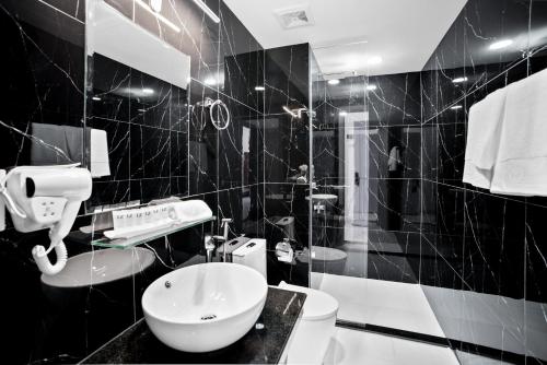 a black and white bathroom with a toilet and a sink at MLZ Apartments Sihanoukville in Sihanoukville