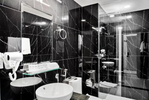 a black and white bathroom with two sinks and a shower at MLZ Apartments Sihanoukville in Sihanoukville