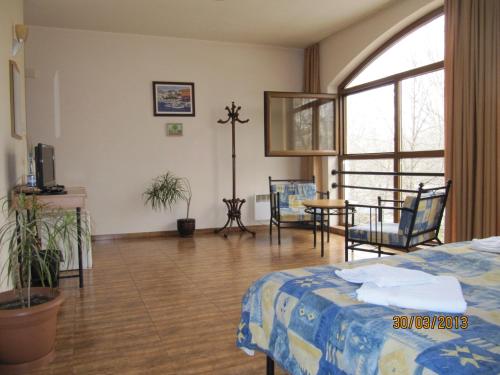 ハスコヴォにあるCentral Family Hotelのベッド、テーブル、椅子が備わる客室です。