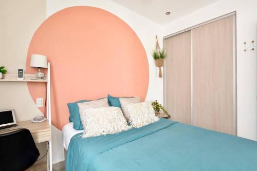 ein Schlafzimmer mit einem blauen Bett und einer orangefarbenen Wand in der Unterkunft Bright & Airy new Condo, 5 min walk to Jaco Beach! in Jacó