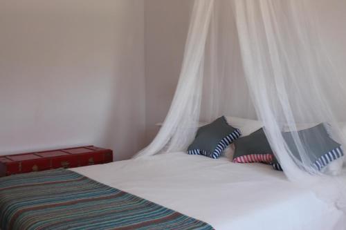 a bedroom with a bed with a mosquito net at Vale do Boto-Quinta com 3 casas in Castro Marim