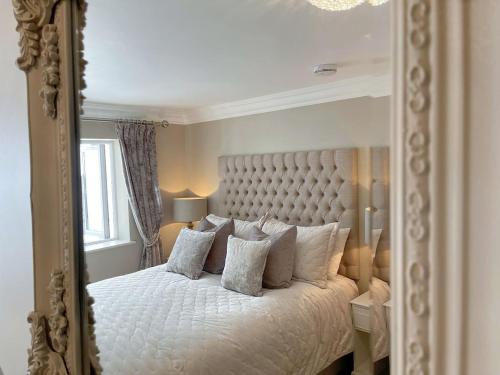 1 dormitorio con 1 cama con espejo grande en The White House Retreat en Findon
