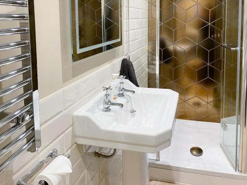 y baño con lavabo y ducha. en The White House Retreat, en Findon