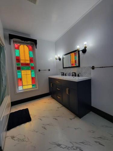 ein Badezimmer mit einem Waschbecken und einem Buntglasfenster in der Unterkunft The Maple Shade Suite in Sussex