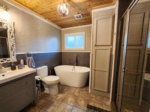 a bathroom with a tub and a toilet and a sink at Cozy Corner in Denison