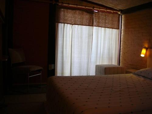 メキシコシティにあるLoft Campestre: A medio Ajusco, cerca de la ciudadのベッドルーム1室(ベッド1台付)、窓(白いカーテン付)
