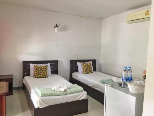 Ban Na Khwai的住宿－Dusita Parkview Resort @ Khua Suan Pla，客房设有两张床和一张带水瓶的书桌。