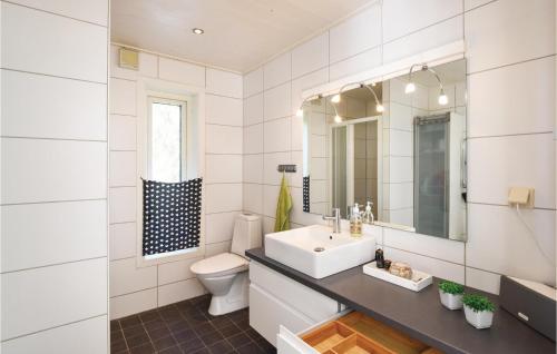uma casa de banho com um lavatório, um WC e um espelho. em Awesome Home In Mellerud With Sauna, Wifi And Jacuzzi em Mellerud
