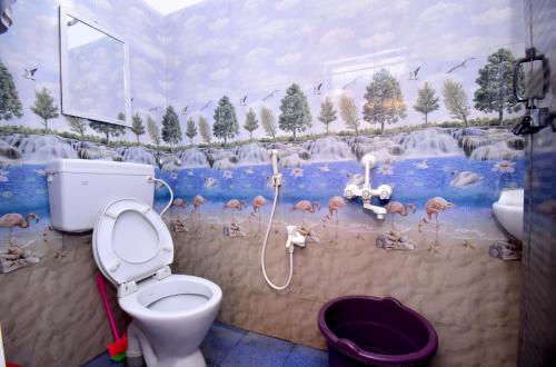 a bathroom with a toilet and a mural of flamingos at Villa Betty Beach Front in Puducherry