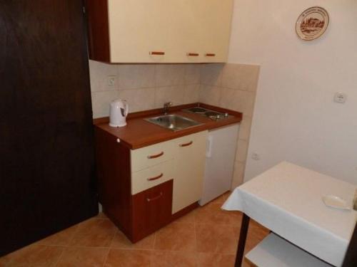 a small kitchen with a sink and a counter at Apartments Ivo in Pag