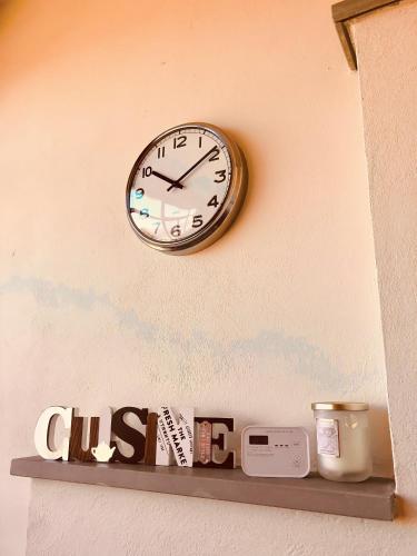 a clock hanging on a wall above a shelf at Villetta rosso Rubino in Vignale Monferrato