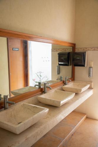 a row of sinks in a bathroom with a mirror at Casa privada con alberca grande in Chetumal