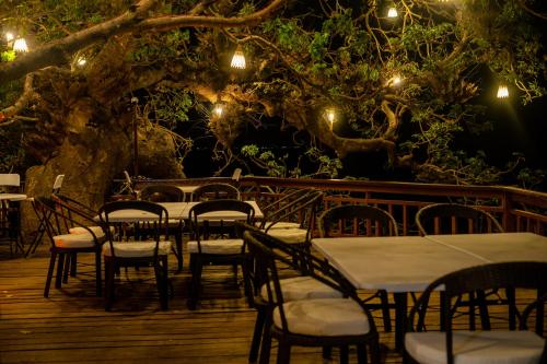 a group of tables and chairs on a deck with lights at Kudugman Beach Cottages - El Nido in El Nido