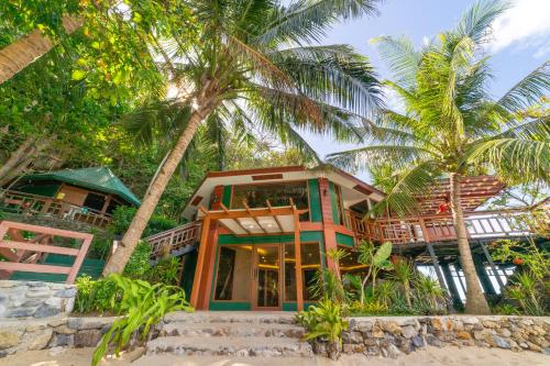 エルニドにあるKudugman Beach Cottages - El Nidoのヤシの木が植えられた浜辺の家