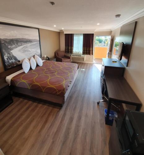 a hotel room with a large bed and a television at Super 8 by Wyndham Cypress Buena Park Area in Cypress