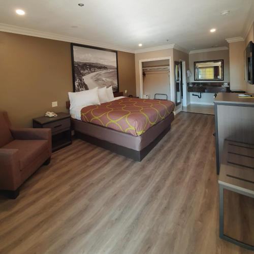 a hotel room with a bed and a couch at Super 8 by Wyndham Cypress Buena Park Area in Cypress