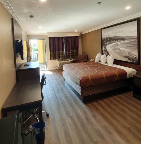 a hotel room with a bed and a desk at Super 8 by Wyndham Cypress Buena Park Area in Cypress