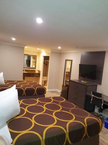 a hotel room with two beds and a flat screen tv at Super 8 by Wyndham Cypress Buena Park Area in Cypress