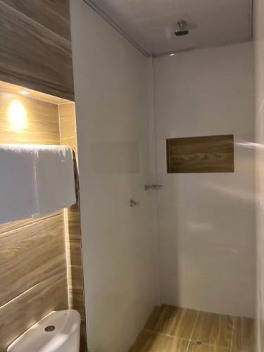 uma casa de banho branca com um WC e um chuveiro em Hotel Palmeras Del Sinu em Lorica
