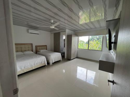 a large bedroom with two beds and a window at Hotel Palmeras Del Sinu in Lorica